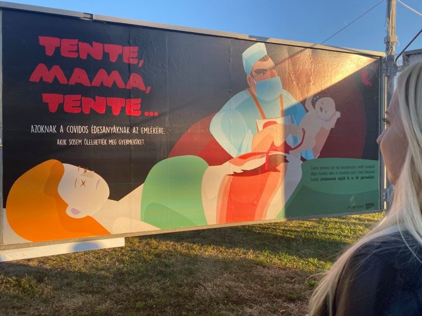 Burián-Barbara-az-arc-kiállításon-nézi-a-Tente-Mama-Tente-című-óriásplakátot